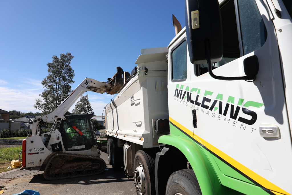 Macleans skid-steer loader clearing a construction site